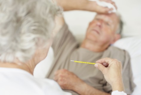 Senior woman caring for man with a fever. Photo : momentimages