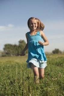 Young girl running in field. Photo : Mike Kemp