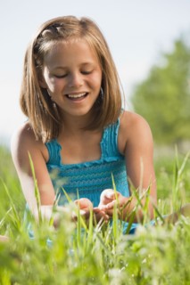 Young girl playing in grass. Photo : Mike Kemp