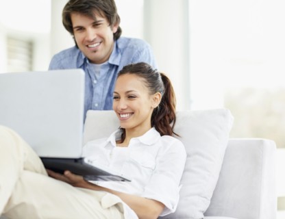 Couple looking at laptop. Photo : momentimages