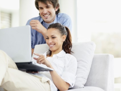 Couple looking at laptop. Photo : momentimages