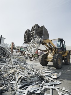 Backhoe lifting recycled metal.