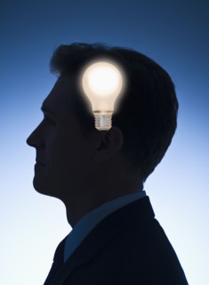 Light bulb in front of profile of a businessman.