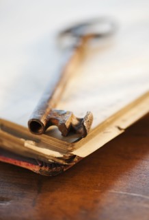 Antique key on top of book.