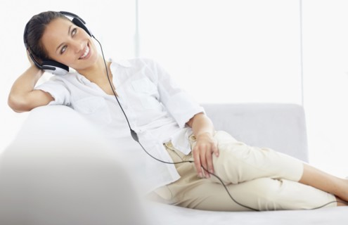 Woman listening to music on headphones. Photo : momentimages