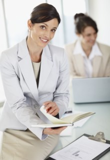 Two businesswomen working in office. Photo : Momentimages