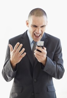 Angry businessman shouting at mobile phone. Photo : Momentimages