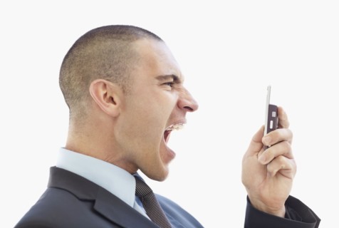 Angry businessman shouting at mobile phone. Photo : Momentimages
