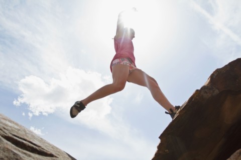 Young woman jumping on rocks. Photo : Johannes Kroemer