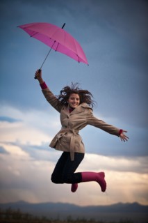 Young woman with umbrella under overcast sky. Photo : Mike Kemp