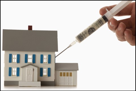 Girls hand (12-13) injecting money into house. Photo : Mike Kemp
