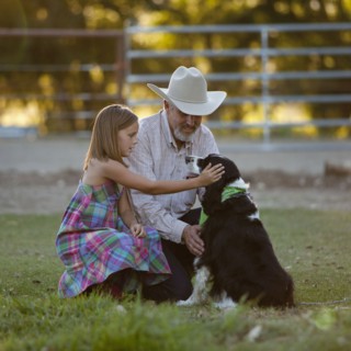 Girl (8-9) stroking dog with grandfather. Photo : Mike Kemp