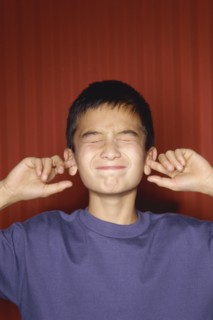 Young boy sticking his fingers in his ears. Photo : Fisher Litwin