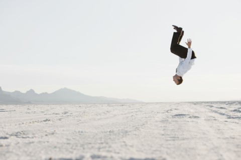 Young man doing backflip in desert. Photo : FBP