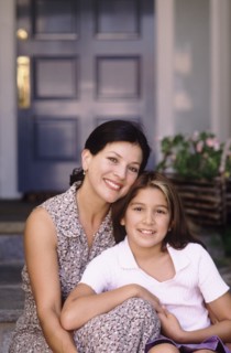 Mother and daughter sitting in front of their home. Photo : Fisher Litwin