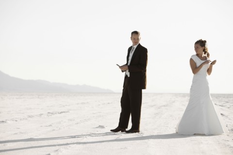 Bride and groom texting in desert. Photo : FBP