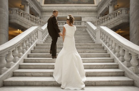 Bride and groom holding hands on steps. Photo : FBP