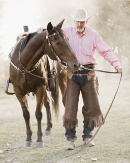 Portrait of senior man with horse in ranch. Photo : Mike Kemp