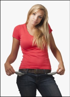 Young woman on white background showing empty pockets. Photo : Mike Kemp