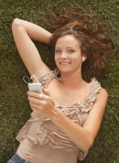 Young girl (16-17) lying on grass. Photo : Mike Kemp