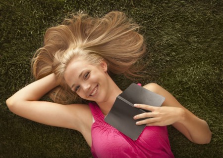 Young girl (16-17) lying on grass. Photo : Mike Kemp