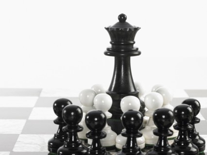 Queen surrounded by pawn chess pieces. Photo : David Arky