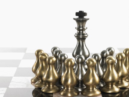 King surrounded by pawn chess pieces. Photo : David Arky