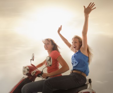 Young girls (16-17) riding scooter. Photo : Mike Kemp