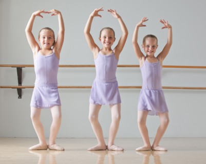 Portrait of three ballet dancers (6-7) in dance studio. Photo : Mike Kemp