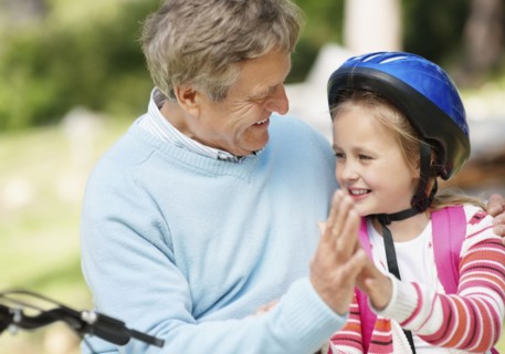 Happy grandfather and granddaughter (10-11) with bike. Photo : Momentimages