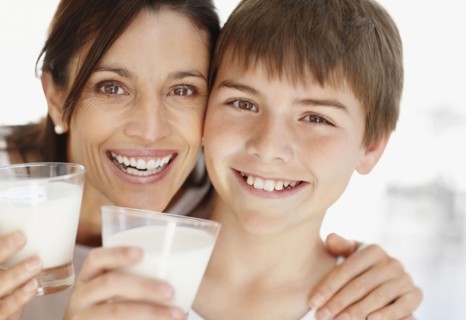 Portrait of smiling mother and son (12-13)  with glasses of milk. Photo : Momentimages
