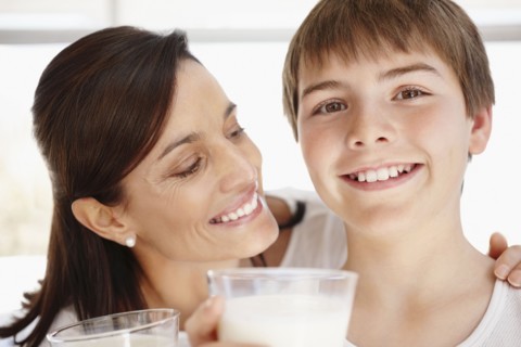 Portrait of smiling mother and son (12-13)  with glasses of milk. Photo : Momentimages