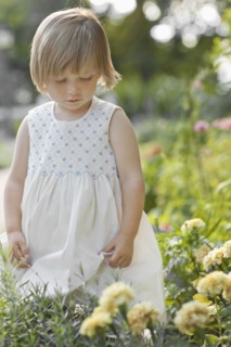 Girl (2-3) by flowers in garden. Photo : FBP