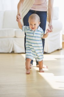 Mother helping son (6-11 months) with first steps. Photo : Daniel Grill