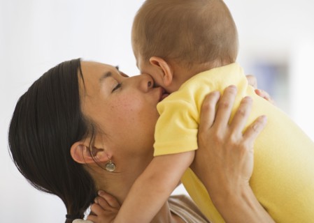 Mother carrying and kissing son (6-11 months). Photo : Daniel Grill