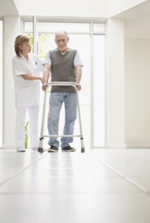 Nurse assisting patient in corridor of clinic. Photo : Momentimages
