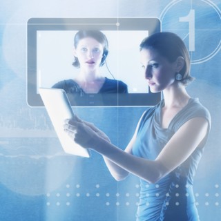 Young woman using tablet in front of monitor.