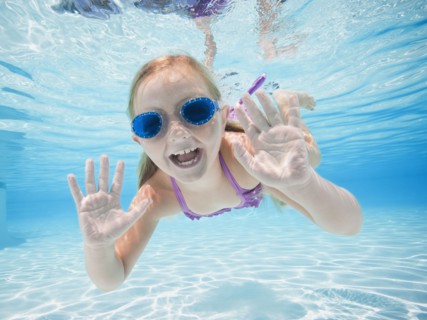 Girl (6-7) swimming underwater.