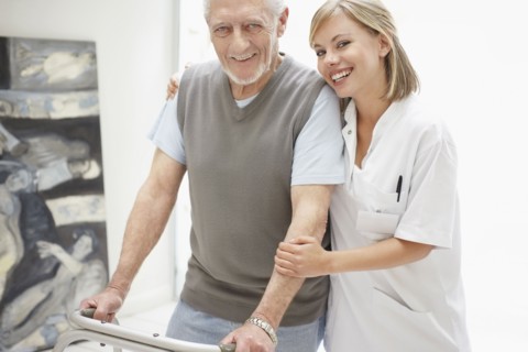 Nurse assisting patient in corridor of clinic. Photo : Momentimages