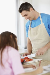 Daughter (10-11) helping father prepare meal . Photo : Momentimages