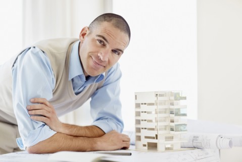 Portrait of architect with apartment model. Photo : Momentimages