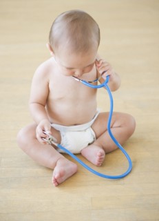 Baby boy (12-17 months) playing with stethoscope. Photo : Daniel Grill