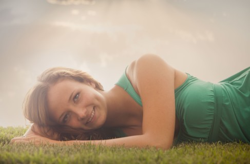 Young girl (16-17) lying on grass. Photo : Mike Kemp