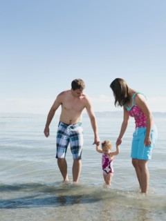 Parents with baby daughter (12-18months) playing on holidays.
