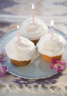Cupcakes with burning birthday candles, high angle view. Photo : Jamie Grill
