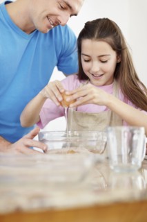 Daughter (10-11) helping father prepare food. Photo : Momentimages