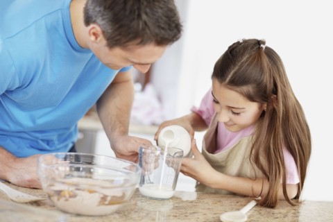 Daughter (10-11) helping father prepare food. Photo : Momentimages