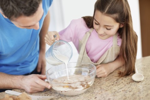 Daughter (10-11) helping father prepare food. Photo : Momentimages