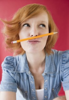 Young woman playing with pencil. Photo : Jamie Grill