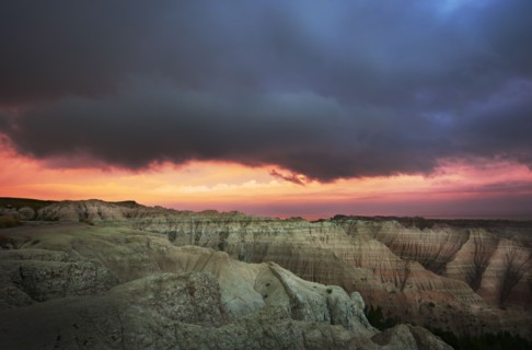 USA, South Dakota, Thick gray clouds over mountains in Badlands National Park at sunset.